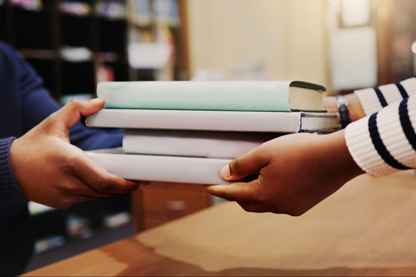 books being handed form one person to another