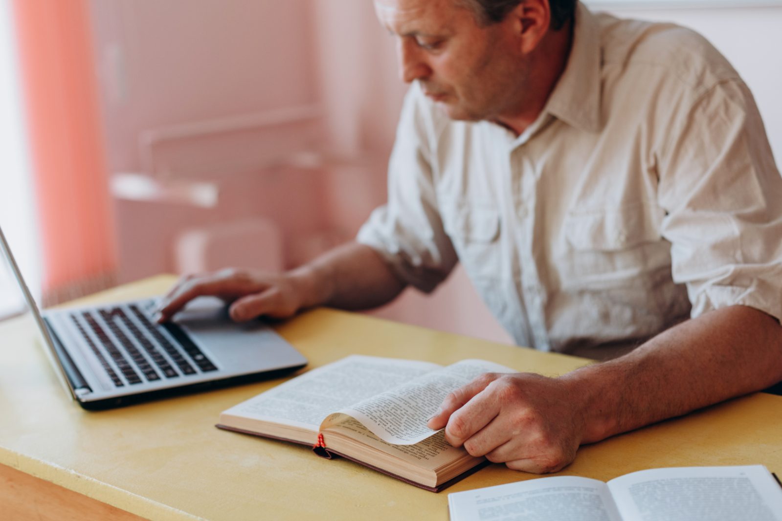 Adult using a laptop and photo to study