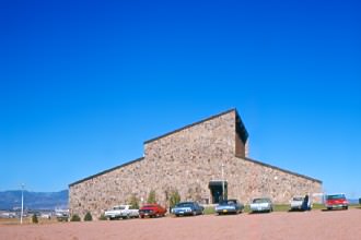 The Administration and Library Building (Sanders Building) and unpaved parking lot.