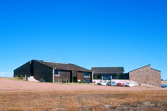 The Classroom Building (Leist Hall) and Student Union Building (Williamson Hall) with the unpaved parking lot in the foreground.