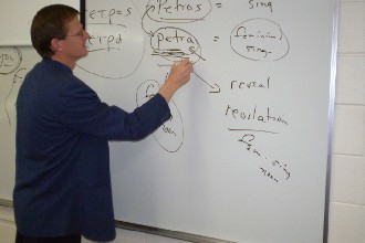 Dr. Powers teaching at a white board.